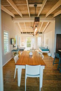 ein Esszimmer mit einem großen Holztisch und weißen Stühlen in der Unterkunft Ocean Front Villa 1 in Culebra