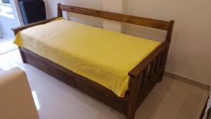 a wooden bed with a yellow sheet on it at Departamento nuevo en San Bernardo in San Bernardo