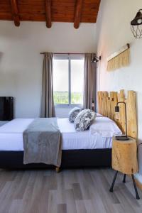 1 dormitorio con 2 camas y ventana en Punta Piedra cabañas & suites en Los Reartes