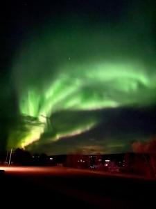 an aurora in the sky over a city at Hótel Eyjafjallajökull in Hellisholar