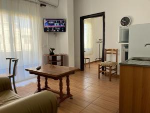 sala de estar con mesa y TV en la pared en COASTAL APARTMENT 9th FLOUR, en Durrës