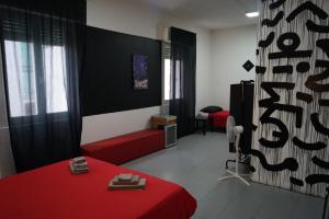una camera con un letto rosso e un divano rosso di Stupido Hotel Rimini a Rimini