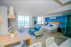 a hotel room with a bed and a living room at Modern Jewel Beachfront Isla Verde in San Juan