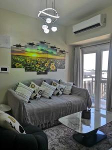 a living room with a couch and a painting on the wall at Saint Honore Executive: 6 guests, 5 beds, 2 bedrooms, 2 bathrms in Iloilo City