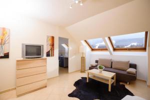 a living room with a couch and a tv at Hirschenhof in Spital am Semmering