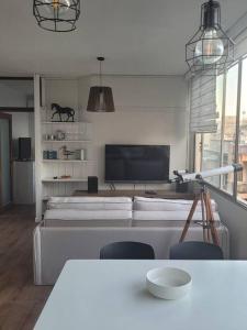 uma sala de estar com televisão e uma mesa com cadeiras em Moderno y Minimalista en Ciudad Vieja Montevideo em Montevidéu
