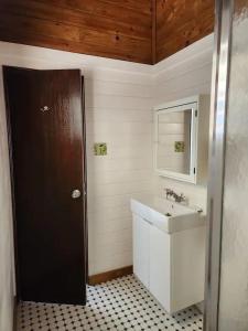 a bathroom with a sink and a black door at Emma by the Bay in Culebra