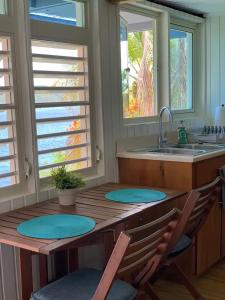 uma cozinha com uma mesa de madeira com cadeiras e um lavatório em Emma's by the Sea em Culebra