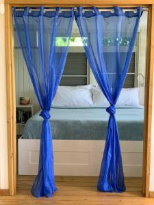 a bed with blue curtains in a bedroom at Emma's by the Sea in Culebra