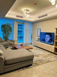een woonkamer met een bank en een flatscreen-tv bij شقه فندقيه بفندق هيلتون المعادي in Caïro