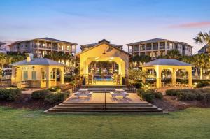 una grande casa gialla con alcuni tavoli di fronte di Endless Summer Nights at Seacrest a Inlet Beach