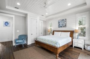 una camera da letto con un letto e una sedia blu di Endless Summer Nights at Seacrest a Inlet Beach Altre 38 foto