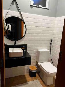 La salle de bains est pourvue d'un lavabo, de toilettes et d'un miroir. dans l'établissement Mansão em Pedra Azul! Exclusividade na região, à Domingos Martins
