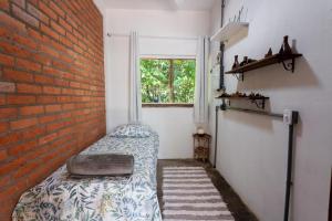 Pokój z łóżkiem przy ceglanej ścianie w obiekcie Espaço Aricá w mieście Chapada dos Guimarães