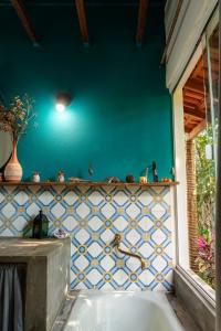baño con pared azul y bañera en Espaço Aricá en Chapada dos Guimarães