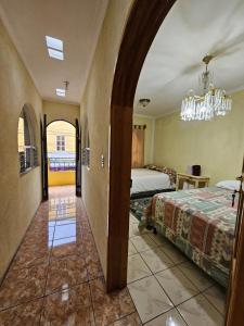 a bedroom with a bed and a chandelier at Hostal flor del lago in Panajachel