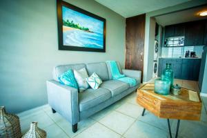 a living room with a couch and a coffee table at Enchanted Jewel 9 Beachfront Pool in Luquillo