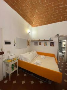 a bedroom with a bed and a table and a brick wall at George’s House in Florence