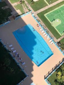 an overhead view of a large swimming pool with chairs at Enchanted Jewel 39 Beachfront Pool in Luquillo