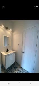 La salle de bains est pourvue d'un lavabo, d'un miroir et d'une porte. dans l'établissement Le Bon Plan, à Montréal