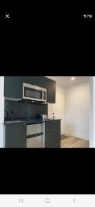 uma cozinha com um micro-ondas e um fogão forno superior em Le Bon Plan em Montréal