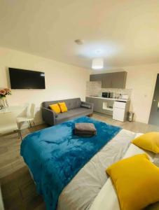 a large bed in a living room with a couch at Roomello luxury City Studios in Peterborough