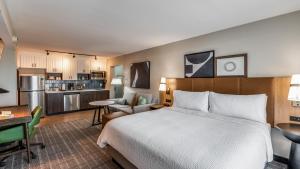 ダラスにあるStaybridge Suites Dallas Market Ctr Love Field, an IHG Hotelのベッドとキッチン付きのホテルルーム