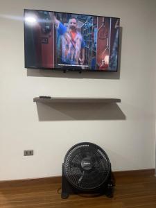 Elle comprend une télévision à écran plat suspendue au mur et un ventilateur. dans l'établissement Hermoso Garzonier plena Esquina del Puente Muyurina, à Cochabamba