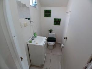 La salle de bains blanche est pourvue de toilettes et d'un lavabo. dans l'établissement Vivienda completa. Privada con acceso controlado. FACTURAMOS, à Hermosillo