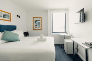 1 dormitorio con cama, escritorio y ventana en Shipwrights Arms Hotel en Hobart