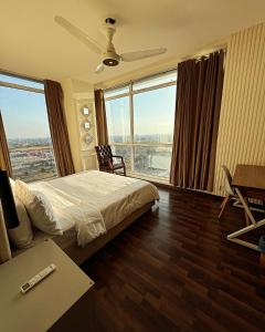 um quarto de hotel com uma cama e uma grande janela em The Presidential Suite Elysium Tower em Islamabad