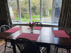 a dining room table with a vase of flowers on it at Tawleat in Okehampton