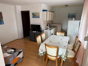 een keuken met een tafel en stoelen en een keuken met een koelkast bij Apartments with a parking space Rogoznica - 22143 in Rogoznica