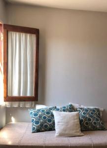 a bedroom with a bed with pillows and a window at Casa Olavarria in San Salvador de Jujuy