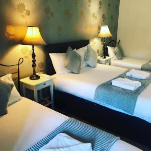 2 Betten in einem Zimmer mit 2 Lampen an Tischen in der Unterkunft Ardenlee Guest House in Edinburgh