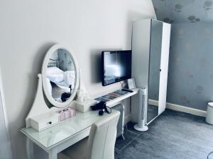 Cette chambre comprend un miroir et un bureau avec un ordinateur. dans l'établissement Ardenlee Guest House, à Édimbourg