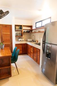 a kitchen with a stainless steel refrigerator and a table at Summer Deals! 800M to Samara Beach 2 BDR in Sámara