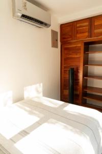 a bedroom with a white bed with a wooden cabinet at Summer Deals! 800M to Samara Beach 2 BDR in Sámara
