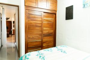 a bedroom with a wooden door and a bed at Summer Deals! 800M to Samara Beach 2 BDR in Sámara