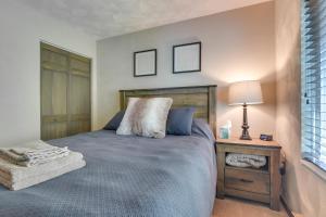 a bedroom with a bed and a table with a lamp at Somerset Townhome with Deck Less Than 2 Mi to Ski Lift! in Champion