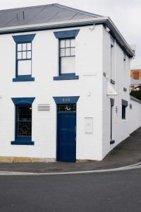 un edificio blanco con una puerta azul y una calle en Shipwrights Arms Hotel, en Hobart