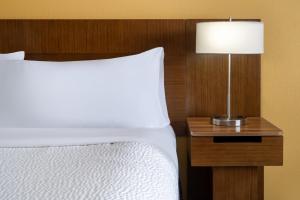 a bed with a lamp on a night stand next to it at Garner Hotel Clarksville Northeast, an IHG Hotel in Clarksville