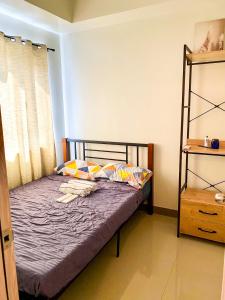 un piccolo letto in una camera con finestra di Casa Aria @ SMDC Charm Residences a Manila