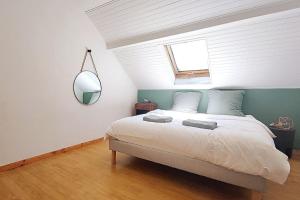 1 dormitorio con cama, ventana y espejo en Maison de ville de 100m2 proche centre-ville/lac en Annecy