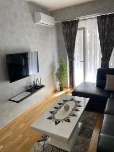uma sala de estar com um sofá e uma mesa de centro em Adriatic apartman em Budva
