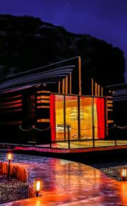 a building with red curtains in front of it at night at Wadi Rum Golden Valley in Wadi Rum