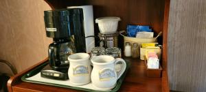 una macchinetta del caffè su una mensola con due tazze da caffè di Evening Shade Inn a Eureka Springs