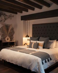 a bedroom with a large bed with a large headboard at Casa 63 Hotel Boutique & Spa - Adults Only in San Miguel de Allende