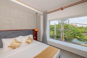 Phumĭ KântrákにあるSerenity Suites d'Angkorのベッドルーム1室(ベッド1台、大きな窓付)