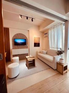 伊洛伊洛Studio K- Japandi-Inspired Condo Unit at The Palladium的带沙发和电视的客厅